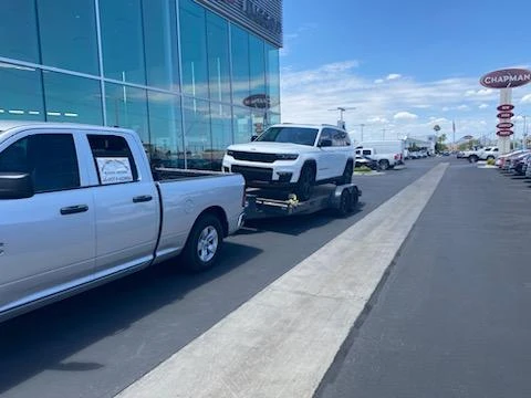 MYS Transportation truck delivering a vehicle at a dealership