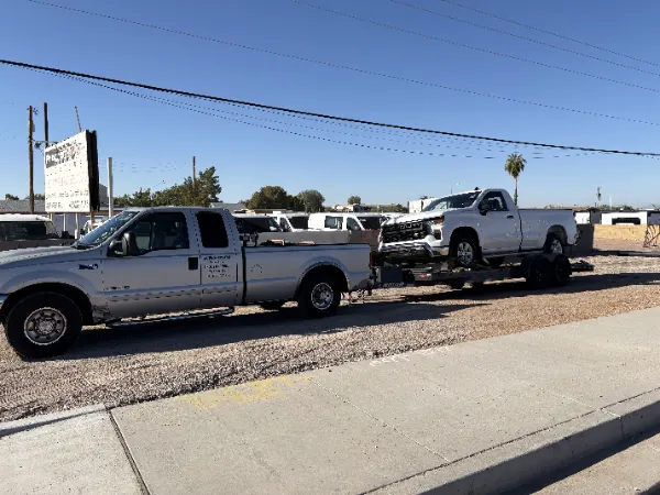 MYS Transportation truck towing a pickup on a trailer